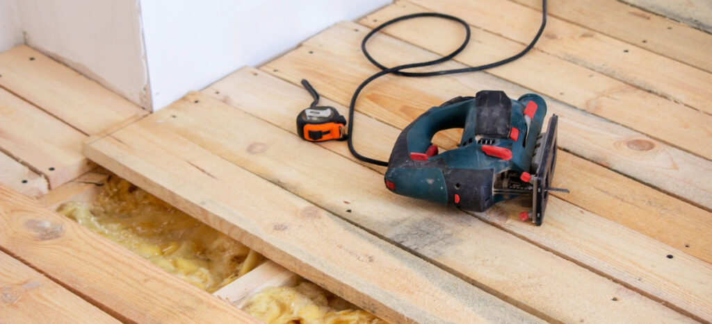 Pose du plancher en bois après l'isolation du plancher bas.