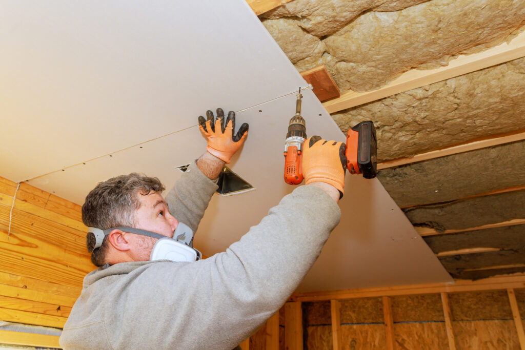 Professionnel en train d'isoler phoniquement plafond.