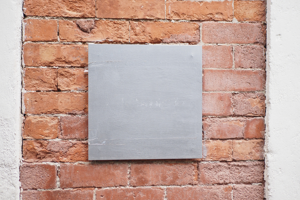 Plaque isolante fixée sur un mur en briques.
