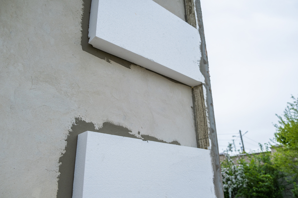 Collage de panneaux isolants lors des travaux d'isolation ite.