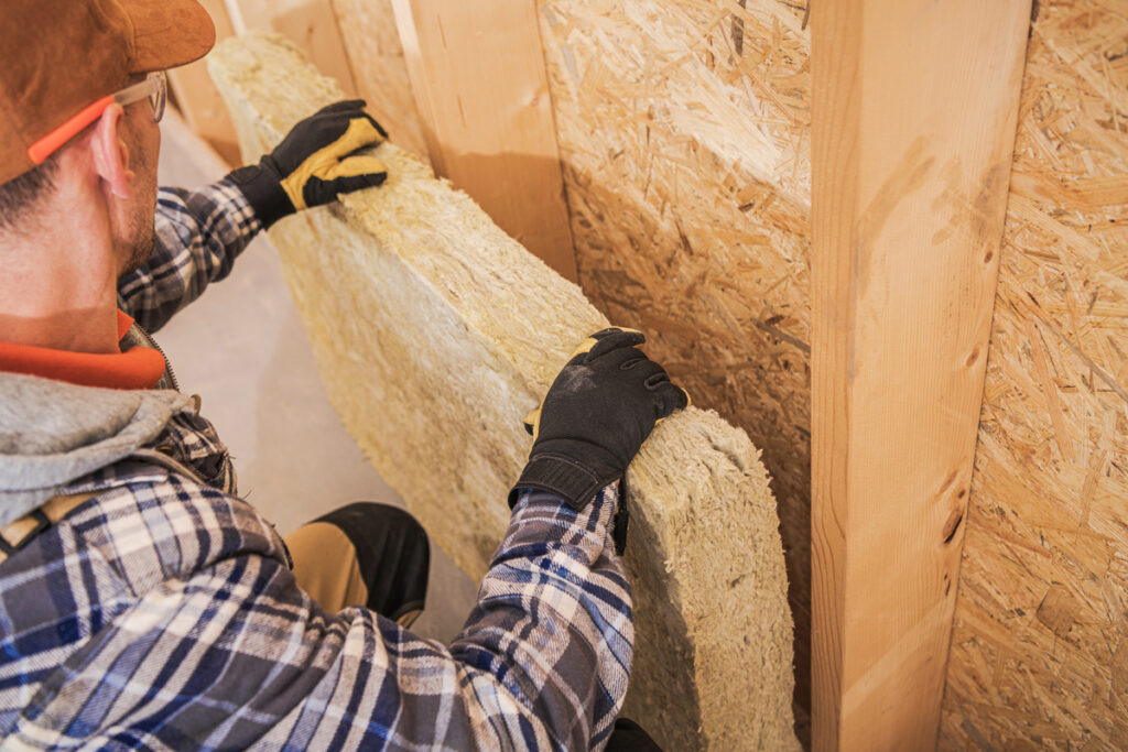 Travaux d'isolation laine de mouton, pose de panneaux souples.